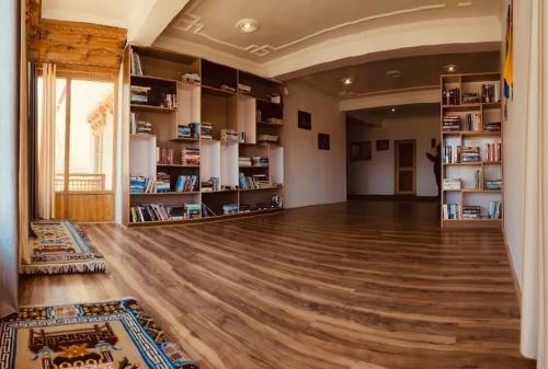 a large room with a hard wood floor and shelves at Sankar Residency in Leh