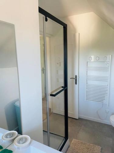 une douche en verre dans une salle de bain avec un lavabo dans l'établissement Maison*Jardin*2 min à pied du centre historique, à Sarlat-la-Canéda