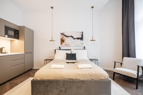 sypialnia z dużym łóżkiem i krzesłem w obiekcie A13- Deluxe Apartments, Best Location, by BQA w Budapeszcie