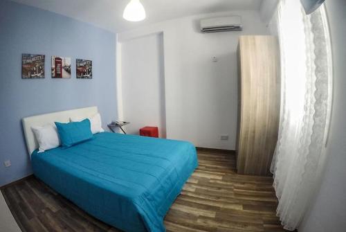 een slaapkamer met een bed met een blauw dekbed bij The Tony in Nicosia