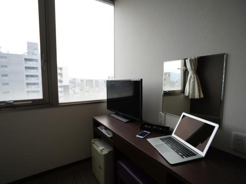 a laptop computer sitting on a desk in a room at Hotel New Gaea Domemae in Fukuoka