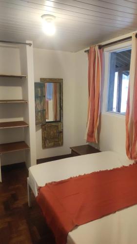 a small bedroom with a bed and a window at Sôsouza in Belo Horizonte