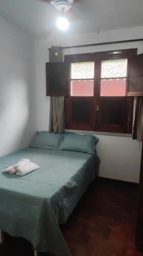 um quarto com uma cama verde e uma janela em Sôsouza em Belo Horizonte