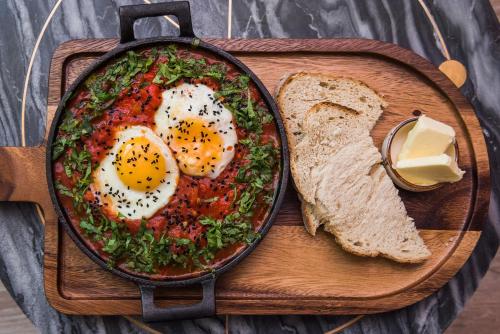 een pan met eieren en brood op een snijplank bij RAJSKA 3 by PI Apartments in Krakau