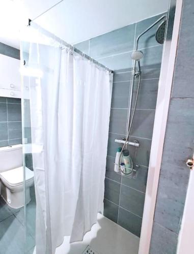 a bathroom with a shower curtain and a toilet at Charming Central Ground Home just off Main ST! in Gibraltar