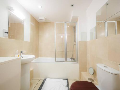 y baño con bañera, aseo y lavamanos. en Pass The Keys Modern 2-Bed Apartment with Private Balcony, Near Dalston Junction Station - Ideal Urban Retreat! en Londres