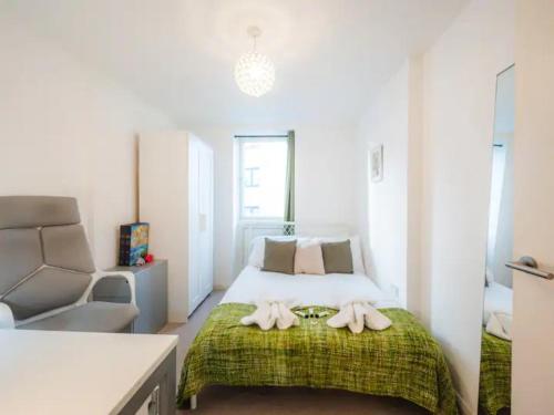 ein Schlafzimmer mit einem Bett mit zwei Handtüchern darauf in der Unterkunft Pass The Keys Modern 2-Bed Apartment with Private Balcony, Near Dalston Junction Station - Ideal Urban Retreat! in London