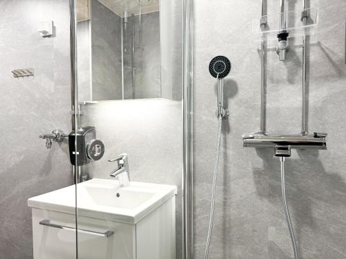 a bathroom with a shower with a toilet and a sink at Aurora City Studio By BookLapland in Rovaniemi