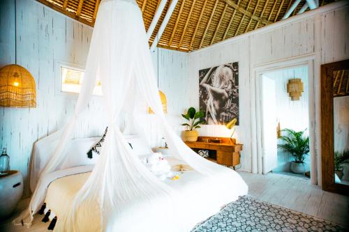 a bedroom with a bed with a mosquito net at Tropical Glamping Nusa Penida Diamond Beach - Cliff Side Edge in Nusa Penida