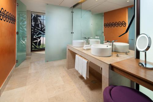 a bathroom with three sinks and two mirrors at W Costa Rica Resort – Playa Conchal in Playa Conchal
