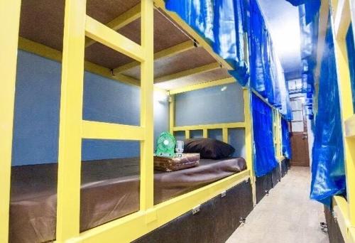 a bedroom with a bunk bed with blue walls at VR hostel สะพานควาย in Bang Su