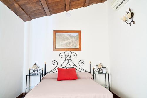 - une chambre avec un lit et un oreiller rouge dans l'établissement El Mirador del Valle, à San Jose del Valle