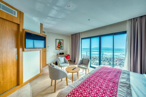 a bedroom with a bed and a table and chairs at Azalaï Hôtel Dakar in Dakar