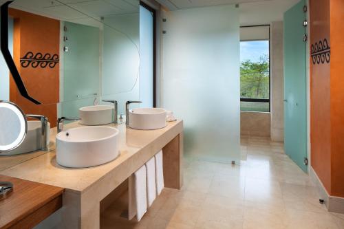 a bathroom with two sinks and a mirror at W Costa Rica Resort – Playa Conchal in Playa Conchal