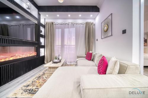 a living room with a couch and a fireplace at Opulent 1BR at Manchester Tower Dubai Marina by Deluxe Holiday Homes in Dubai
