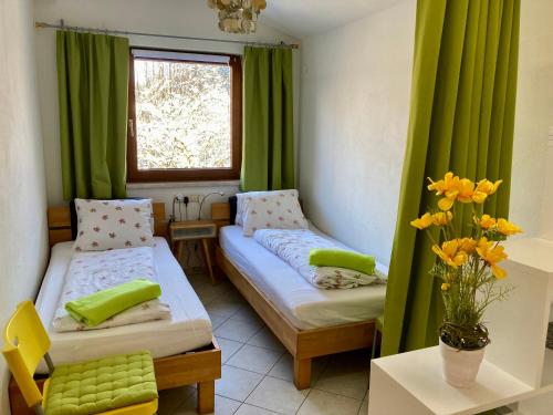 Zimmer mit 2 Betten und einem Fenster mit grünen Vorhängen in der Unterkunft Wessely Appartements am Golfplatz in Innsbruck