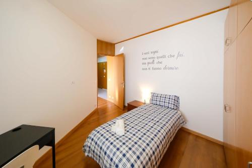 a small bedroom with a bed and a sign on the wall at Udine FRONTE OSPEDALE in Udine
