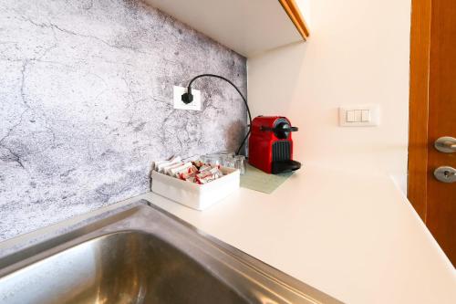 ウーディネにあるUdine FRONTE OSPEDALEのバスルーム(シンク、赤い電化製品付)