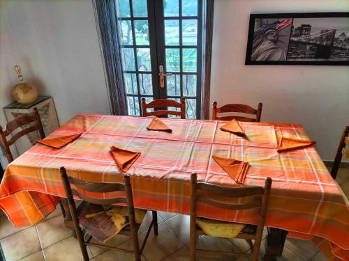 uma mesa de jantar com uma toalha de mesa vermelha e laranja em Appartement dans villa Niçoise em Nice