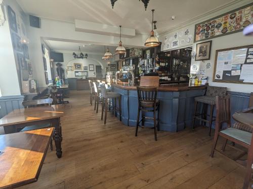 a bar in a restaurant with wooden tables and chairs at The Seal in Selsey