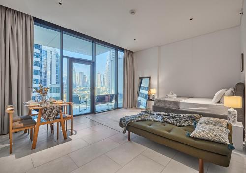 sypialnia z łóżkiem i pokój z widokiem w obiekcie Luxury Studios with Burj Khalifa or Canal View in Downtown - Marquise Square Tower w Dubaju