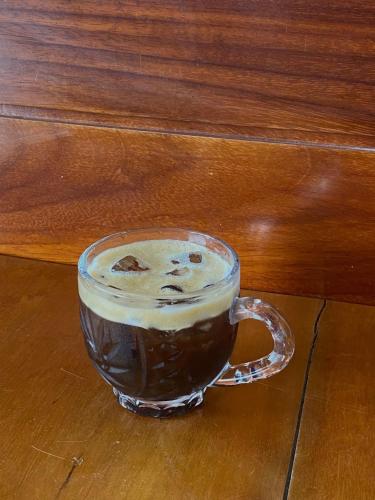 a glass cup of coffee sitting on a table at Hà Tiên Hạnh Phúc Hotel in Ha Tien