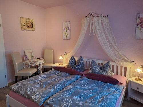 1 dormitorio con 1 cama azul con dosel en Pension Sander, en Bispingen