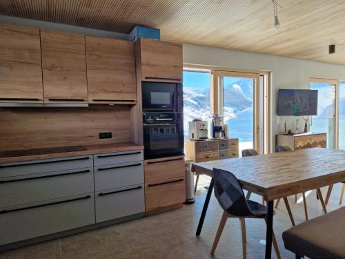 a kitchen with wooden cabinets and a table with a dining room at Le 4 in Les Deux Alpes