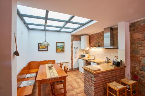 a kitchen and dining room with a skylight at Rincón de piedra BCN in Corró de Vall