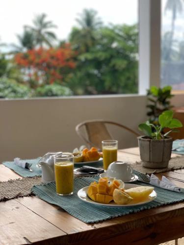 a table with a plate of orange juice and orange slices at Mlango Paje House II in Paje