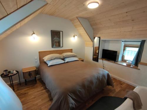um quarto com uma cama grande e uma televisão em Chambres d'hôtes, Zimmer, Domaine de Kervennec em Carhaix-Plouguer