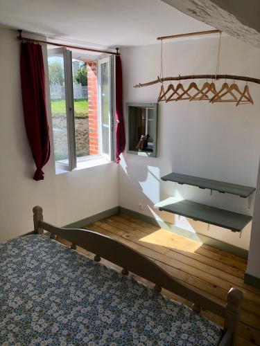a bedroom with a wooden bed and a window at Moulin de Saint-Civran in Saint-Civran