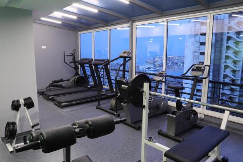a gym with tread machines and a view of the city at Warwick Palm Beach Hotel in Beirut