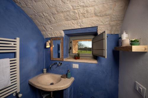 a bathroom with a sink and a blue wall at Le Dieci Porte in Alberobello