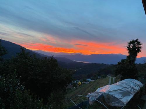 uma tenda ao lado de uma colina ao pôr-do-sol em Appartamento di vacanza tra i vigneti 