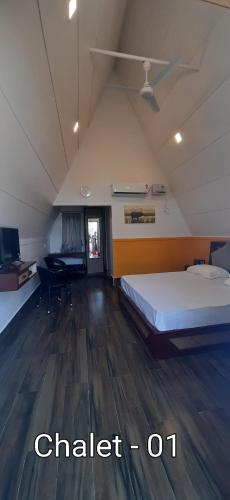 a room with a bed and a desk in it at Villa Shivalay in Dergaon