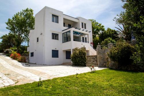 a large white house with a yard at Plakias Villas in Lefkogeia