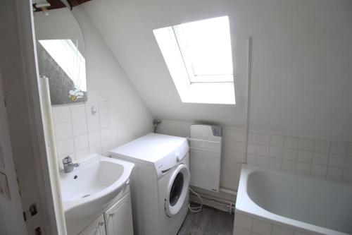 La salle de bains blanche est pourvue d'un lavabo et d'un lave-linge. dans l'établissement Appartement duplex, à Pont-Sainte-Maxence