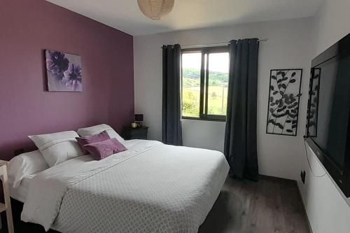 a bedroom with a white bed and a window at Villa avec piscine chauffée Périgord Dordogne in Marnac