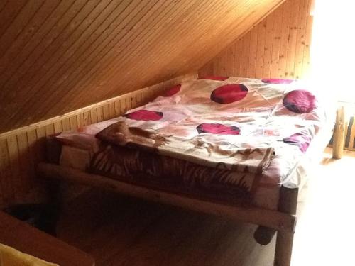 a bed with red pillows on it in a room at Lakefront House & Sauna Mazury, quiet beautiful village, domekprzytulny in Ełk