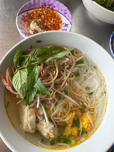 a bowl of noodle soup with meat and vegetables at Hà Tiên Hạnh Phúc Hotel in Ha Tien