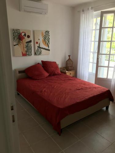 una camera da letto con un letto con lenzuola rosse e una finestra di Maison Périgoudine a Saint-Philippe-dʼAiguille