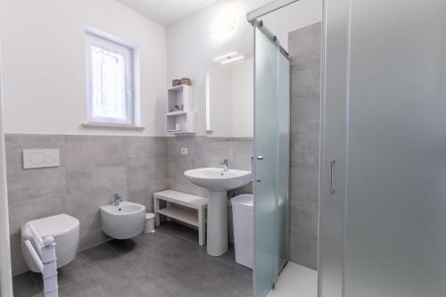 een witte badkamer met een wastafel en een toilet bij Bed gold in Castelnuovo del Garda