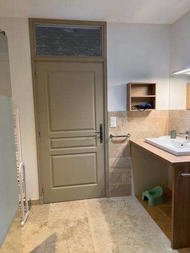 a bathroom with a door next to a sink at LA CHARMILLE Jolie maison de campagne 14 personnes piscine calme in Entrains-sur-Nohain