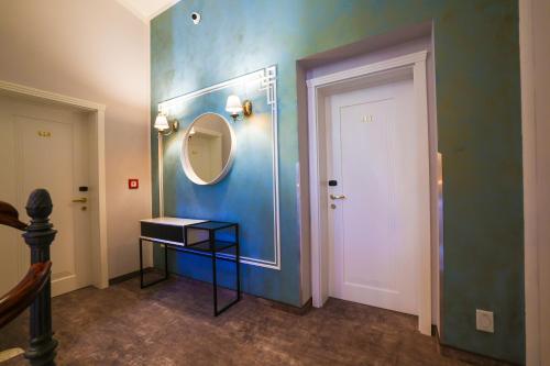 a room with a mirror and a door with a table at Boutique Hotel Ambiente ****+ in Karlovy Vary