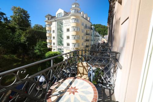 a balcony with an umbrella and a building at Boutique Hotel Ambiente ****+ in Karlovy Vary