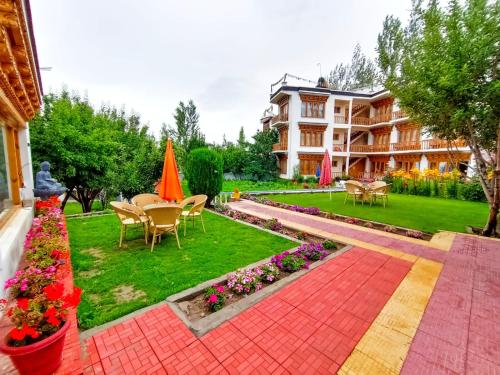 a resort with a garden with tables and chairs and flowers at Kidar in Leh