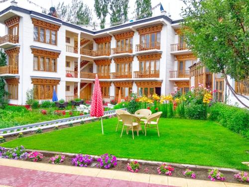 a building with a yard with chairs and flowers at Kidar in Leh