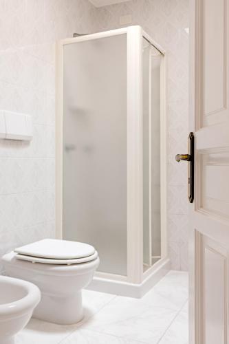 a white bathroom with a toilet and a shower at Hotel Da Raffaele in Ischia
