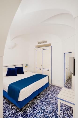 a bedroom with a blue and white bed and a mirror at Hotel Da Raffaele in Ischia